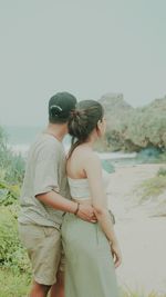 Side view of couple standing at beach