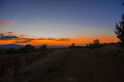 Scenic view of silhouette field against sky during sunset