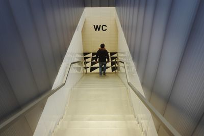 Rear view of a man walking in corridor