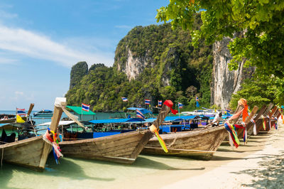 Boats moored at beach against sky