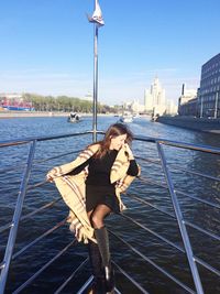 Young woman in boat sailing on river against sky