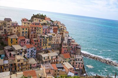 High angle view of townscape by sea against sky