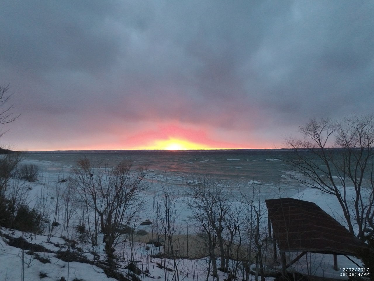 SCENIC VIEW OF FROZEN RIVER AGAINST DRAMATIC SKY