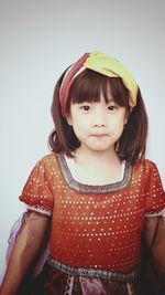 Portrait of girl in costume standing against wall at home