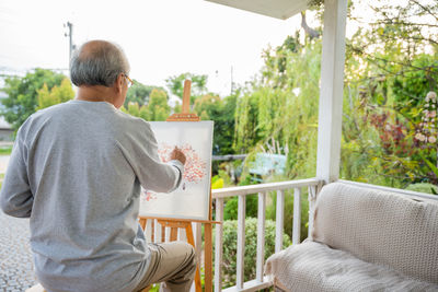 Side view of man looking through window