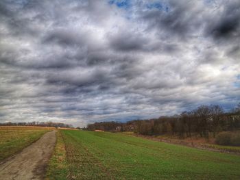Scenic view of field against cloudy sky