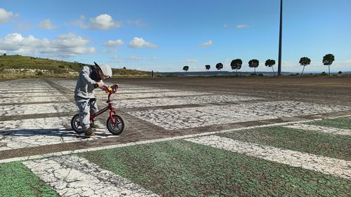 Man riding bicycle on road against sky