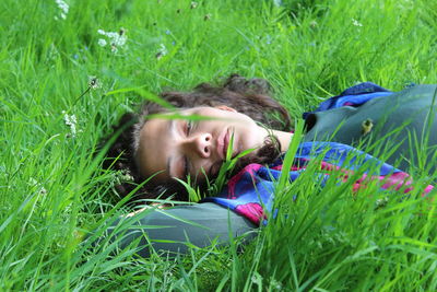 Portrait of girl lying on grassy field