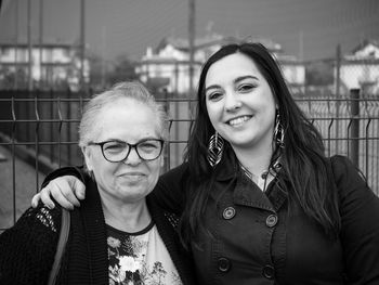 Portrait of smiling mother and daughter in city