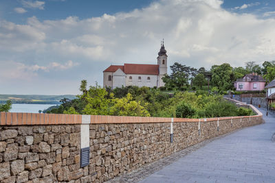 Road by sea against cloudy sky