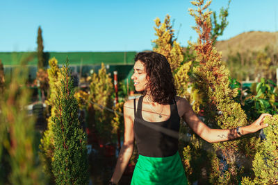 Young woman standing by plants