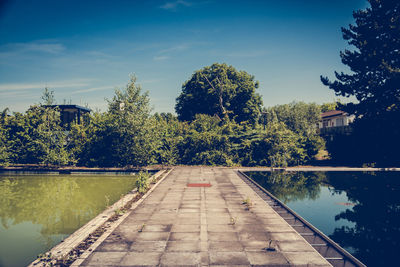 Reflection of trees in unused, decayed pool