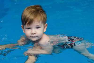 Little boy learns to swim in the pool. swimming for newborns.