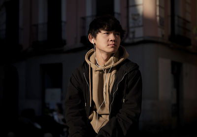 Asian teenage boy with earphones on street. madrid. spain