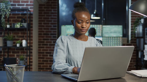 Businesswoman using laptop at home