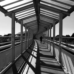 Rear view of man walking on bridge