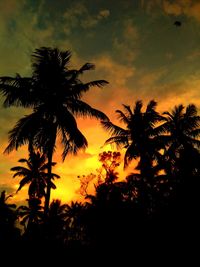 Silhouette palm trees against romantic sky at sunset