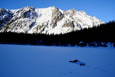 Scenic view of snowcapped mountains against clear blue sky