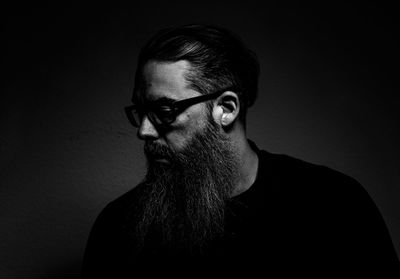 Portrait of young man against black background