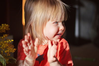 Cute baby girl looking away and smiling while at home