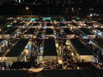 High angle view of people in illuminated flea market at night