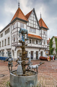 Statue by street against buildings in city