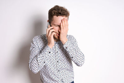 Smiling young business man in a light shirt posing on a light background