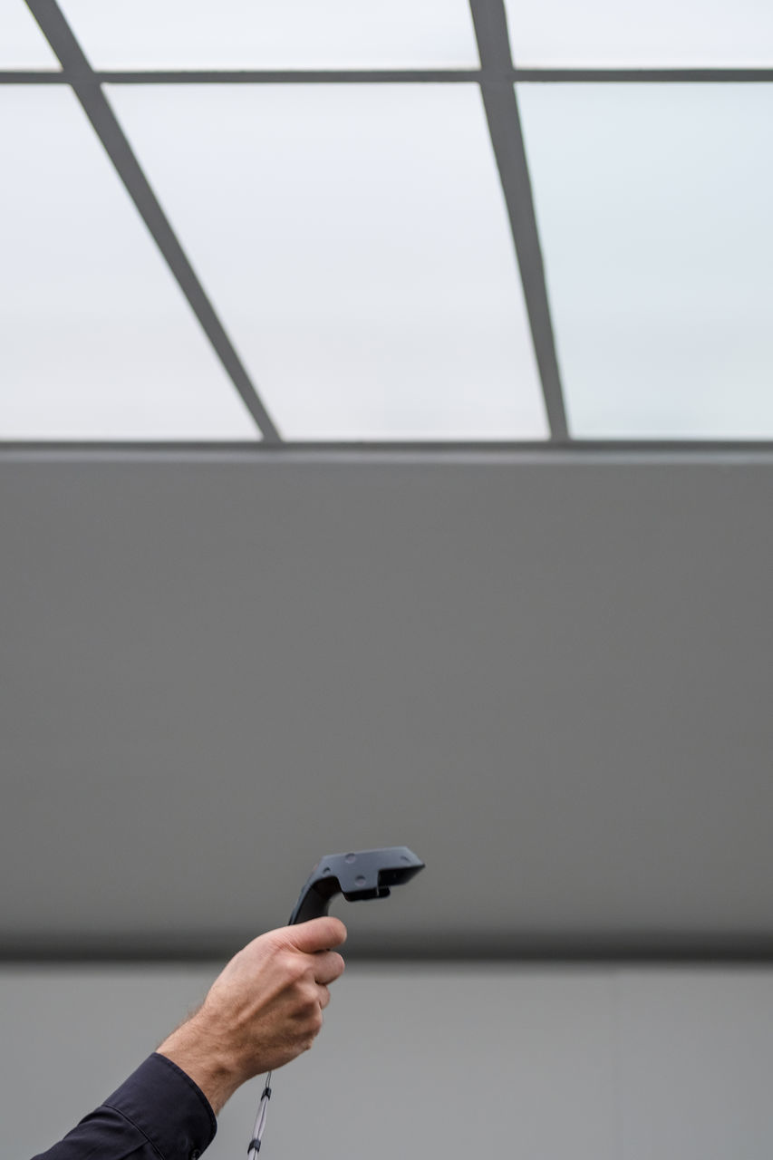 PERSON HOLDING UMBRELLA AGAINST WALL