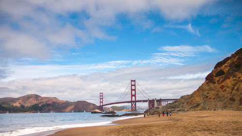 View of suspension bridge against cloudy sky