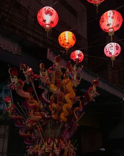 Low angle view of illuminated lanterns hanging at night