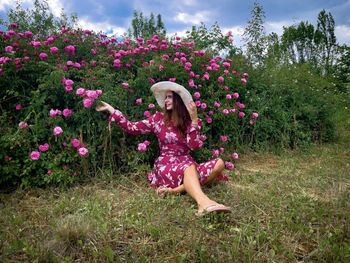 Low angle view of woman with pink flower on field
