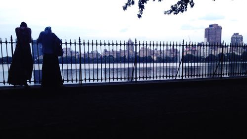 Woman looking at city at sunset