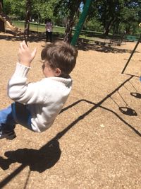 High angle view of boy in park on sunny day