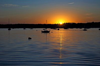 Silhouette sailboats in lake against sky during sunset