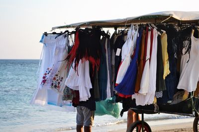 Clothes drying on beach against clear sky