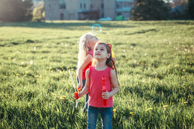 Girls on field against sky