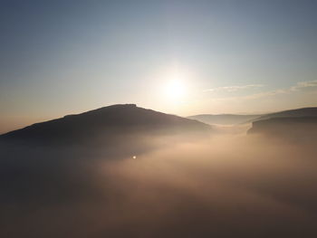 Scenic view of silhouette mountains against sky during sunset