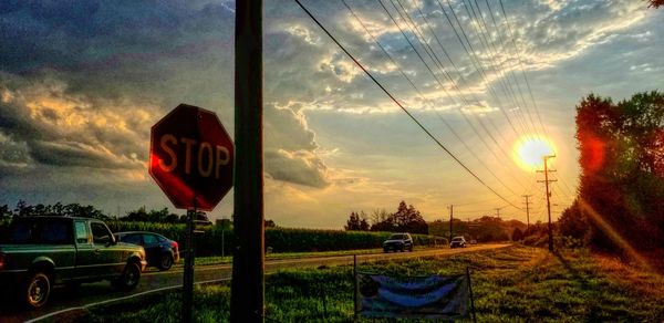 Cars on road against sky during sunset