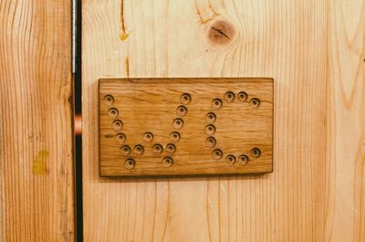 Close-up of restroom sign on wood