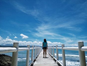 Rear view of man looking at sea against sky