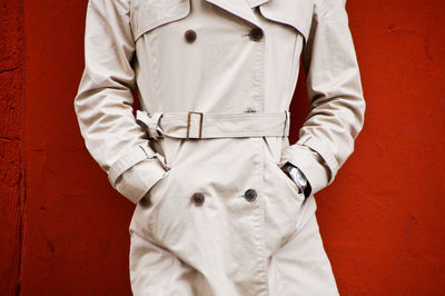 Midsection of man standing by red wall