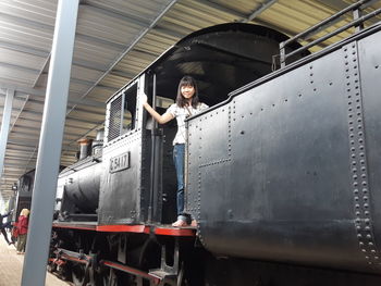 Portrait of young woman standing in steam train