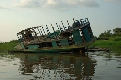 Abandoned ship in water against sky