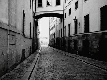 Empty walkway amidst buildings