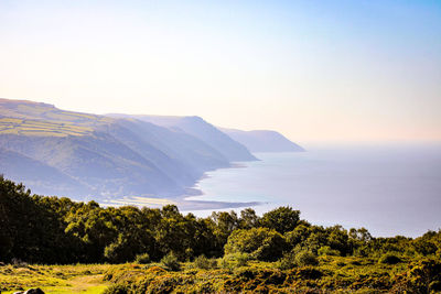 Scenic view of sea and mountains against clear sky