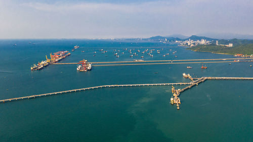 Seascape and oil station bridge with sailing shipping oil and gas on the green sea aerial view 