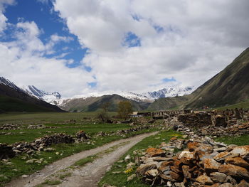 Road leading towards mountains against sky