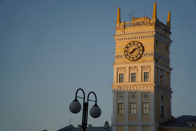 Low angle view of clock tower amidst buildings against sky