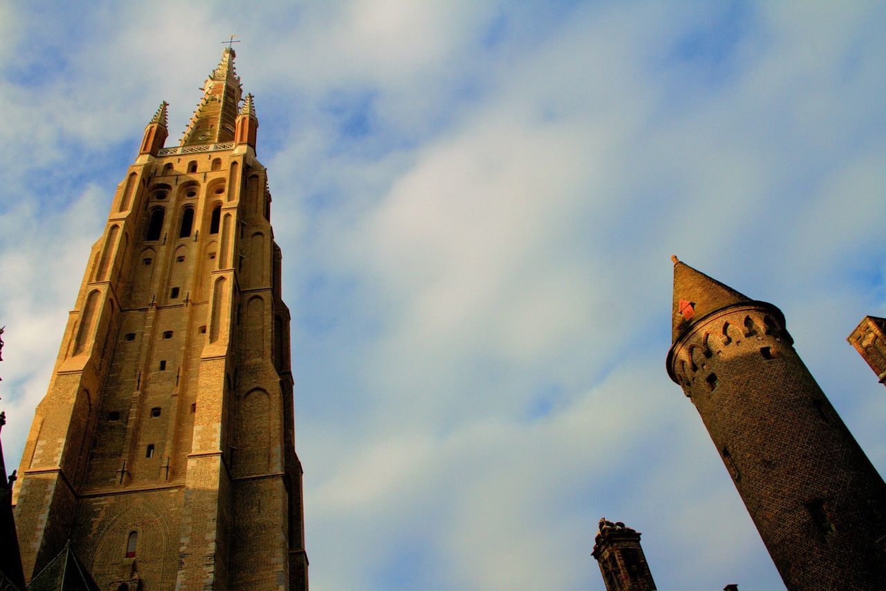 low angle view, architecture, sky, building exterior, built structure, religion, cloud - sky, place of worship, church, spirituality, tower, cloudy, cloud, clock tower, history, cathedral, outdoors, tall - high