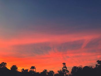 Low angle view of silhouette trees against romantic sky